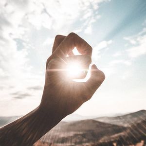 Una mano capturando el sol